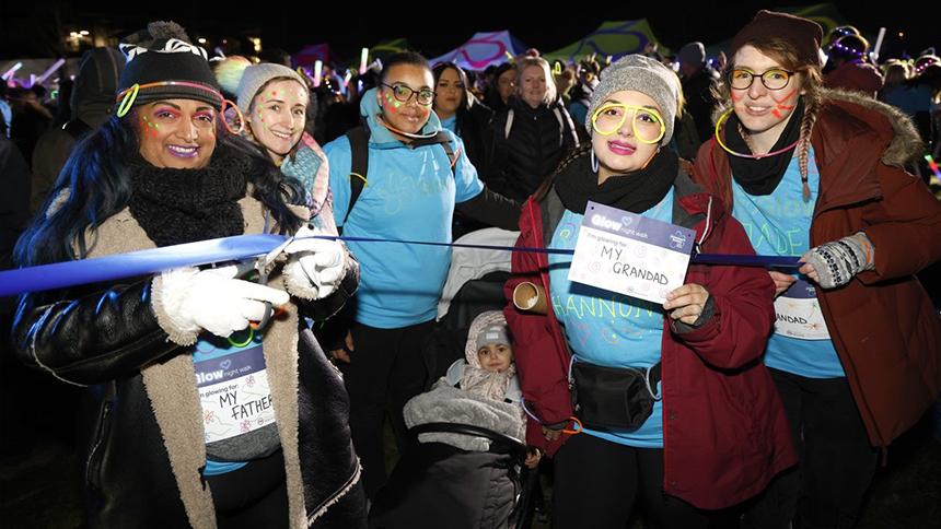 Genevieve Fernandes cuts the start ribbon with friends and family at a Glow Walk