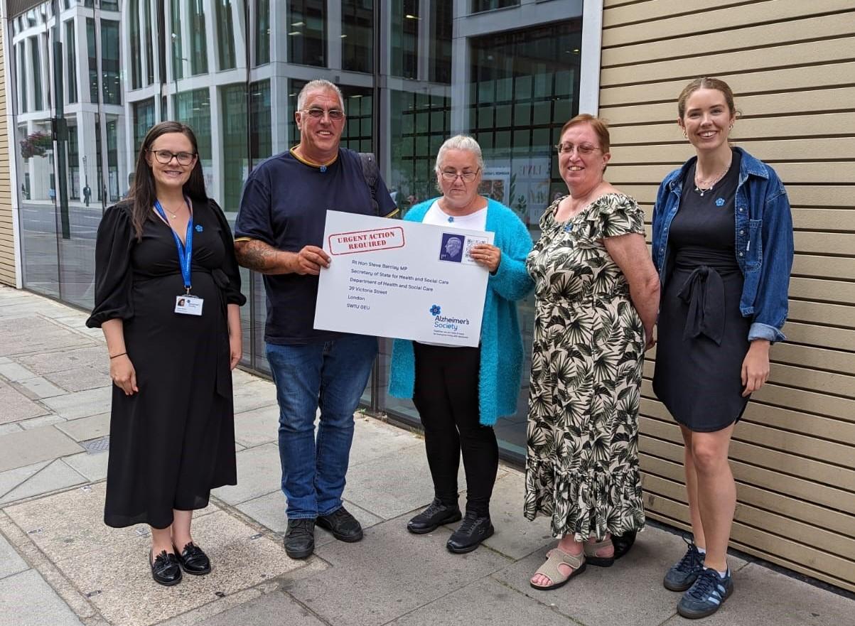 Alzheimer's Society staff with Paul, Sandra and Jeannette holding the open letter outside the Department of Health and Social Care