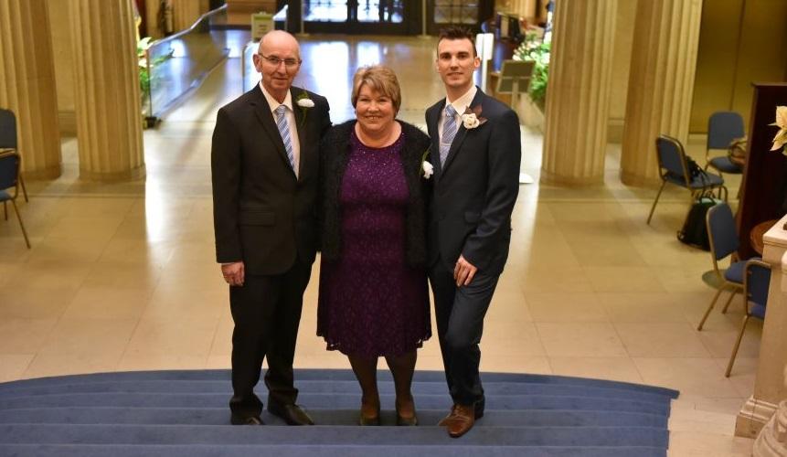 Craig (right) stands with his parents on his wedding day