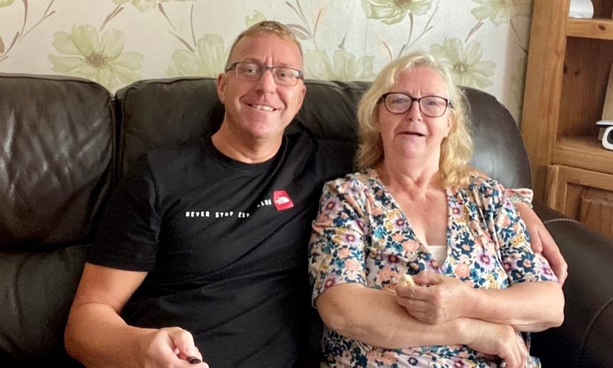 Alan and his mum Jackie arm in arm on the sofa