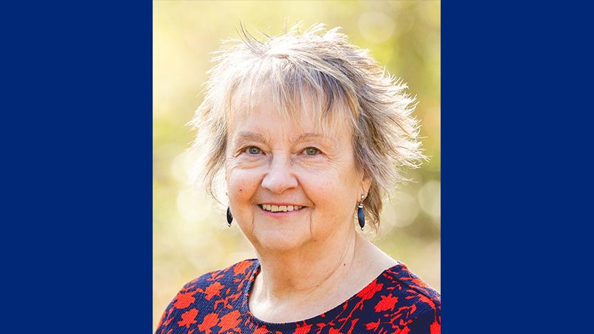 Ruth Chauhan smiles at the camera while outdoors