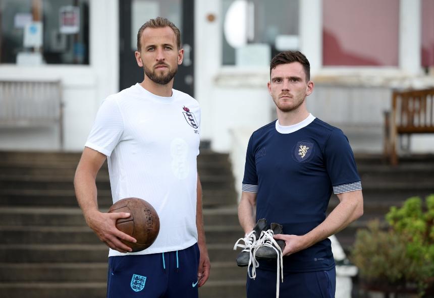 England captain, Kane, and Scotland captain, Robertson, stand with an old style football and football boots