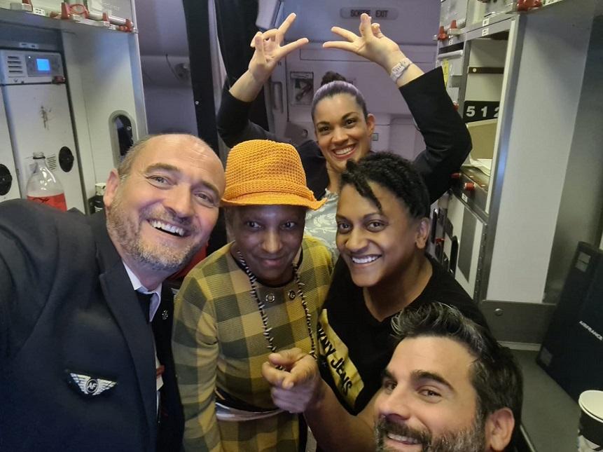 Armelle and Chantal pose for a photo on a plane with a group of air cabin crew