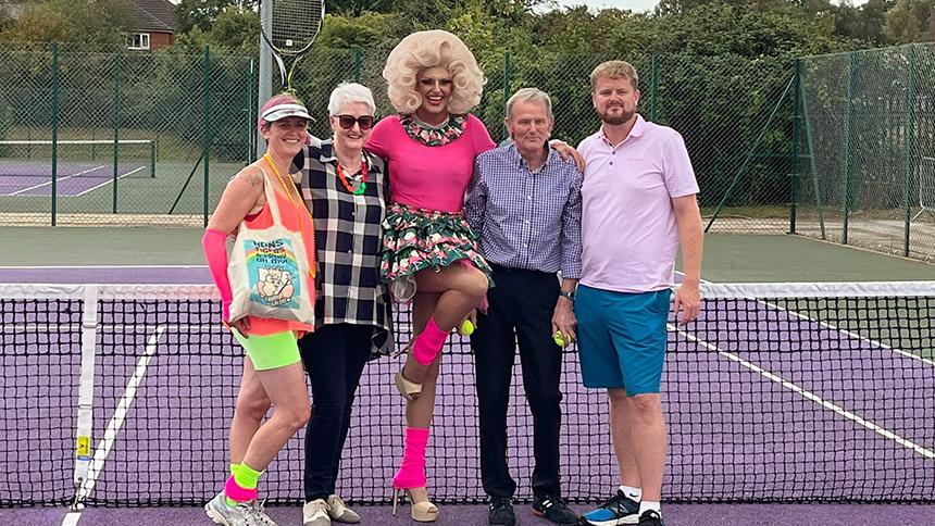 Craig Whymark as Fanny Galore (middle) on a tennis court surrounded by his family, his dad Trevor stands to his left
