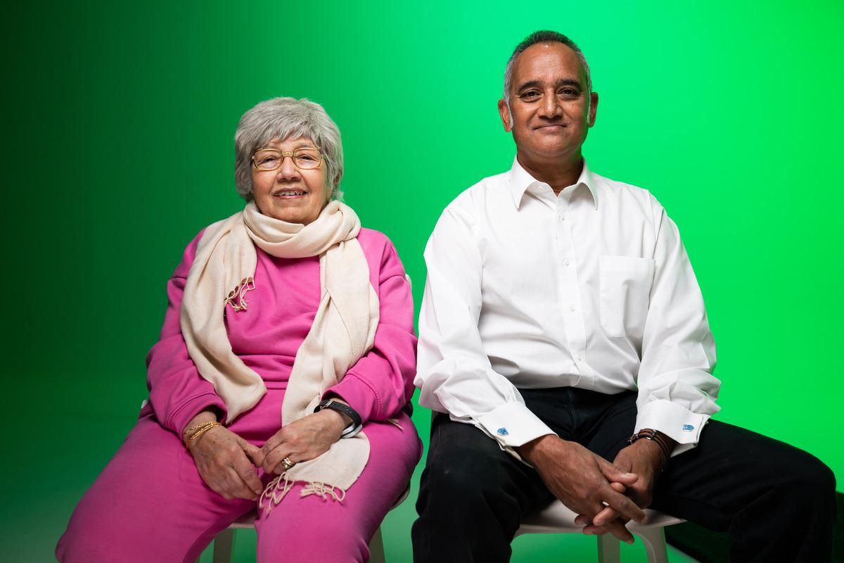 Alma and Errol sitting against a green background