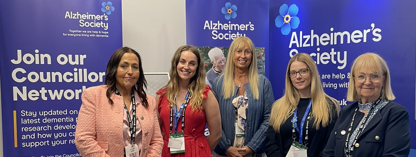 A group of women stand before Alzheimer's Society 'Councillor network' banners.