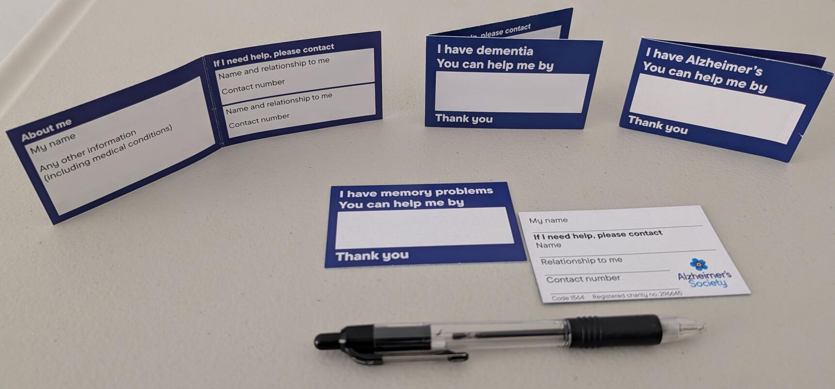 Alzheimer's Society helpcards and a pen on a table