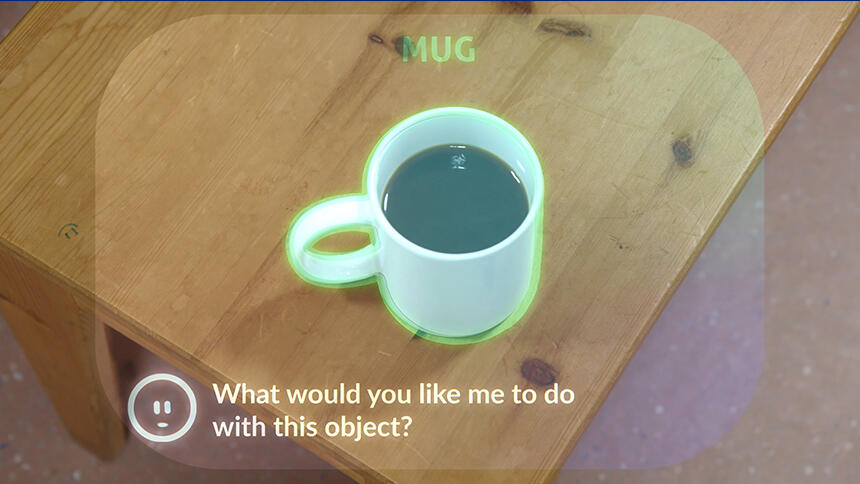 View through smartglasses of a mug on a table, with a prompt from Wispy asking, 'What would you like to do with this object?'
