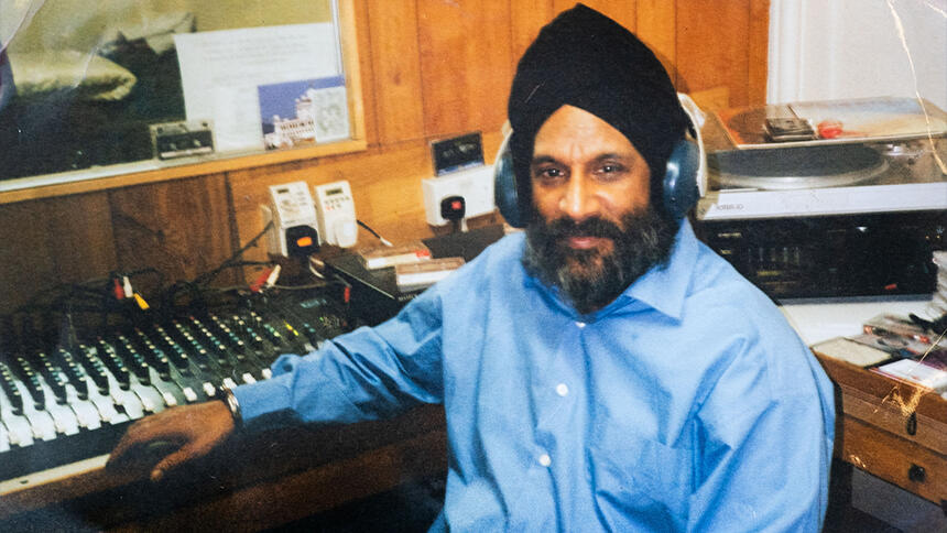 Harjit Singh Sagu in younger days, sitting at a radio mixing desk