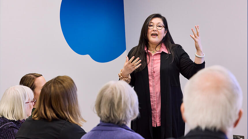 A Dementia Friends Ambassador speaking to a roomful of people at a session