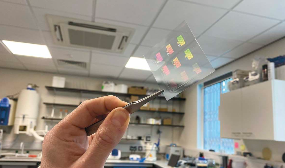 A piece of near-transparent film held up by laboratory tweezers 