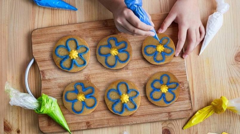 Image of child icing Forget-me-not biscuits