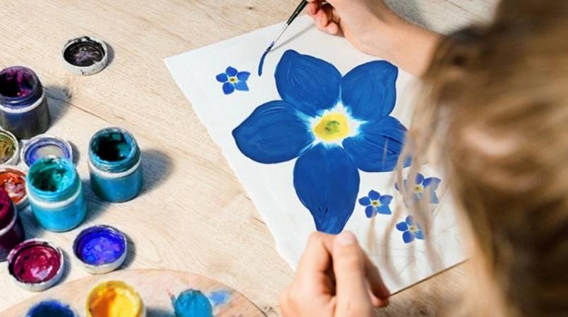 Image of child painting forget-me-nots