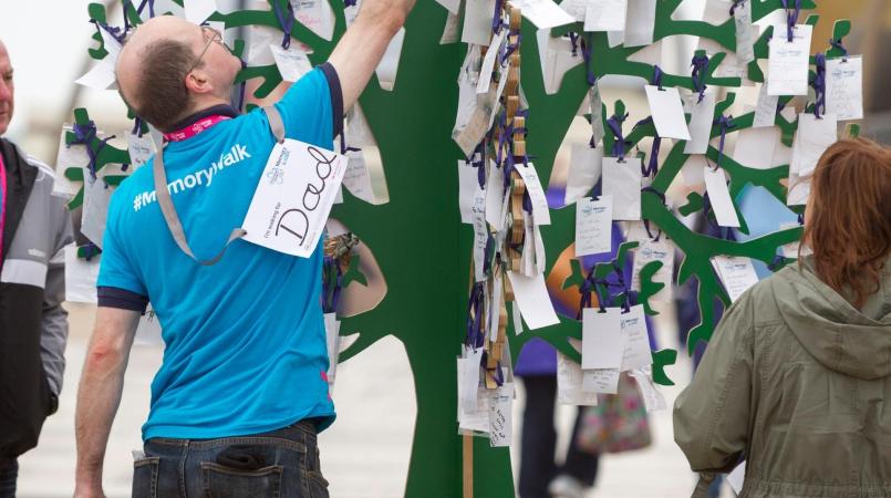 Man hanging a tag on the memory tree