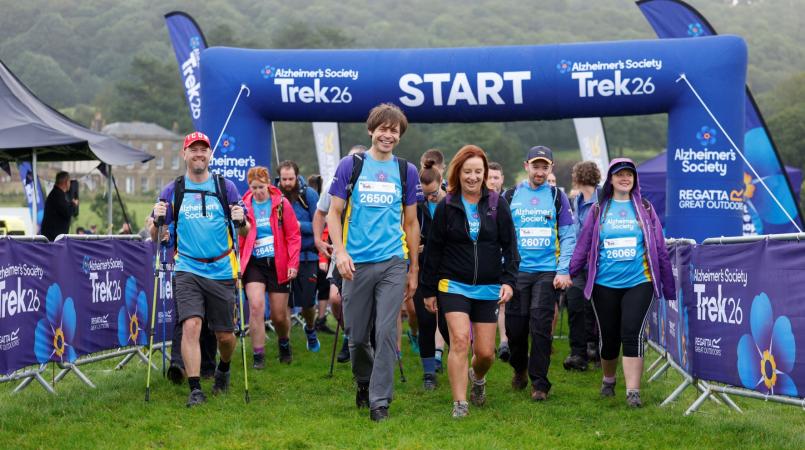 Group of trekkers setting off under a start line