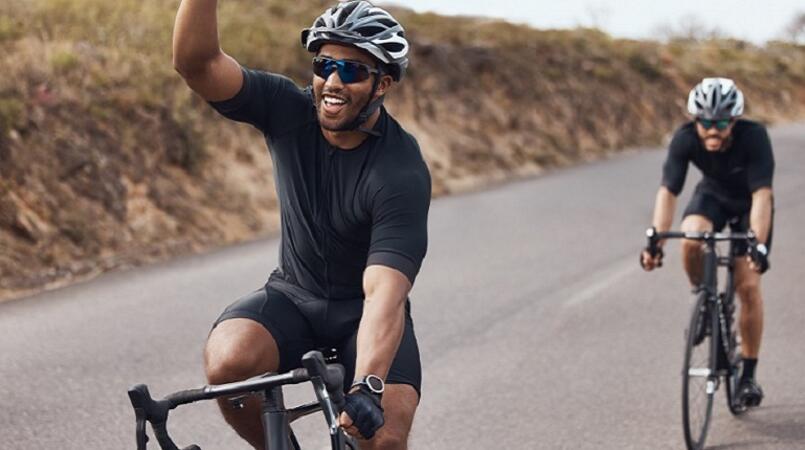 Two men cycling on an open road.
