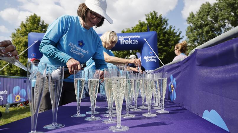 Volunteer filling drinks glasses at finish line