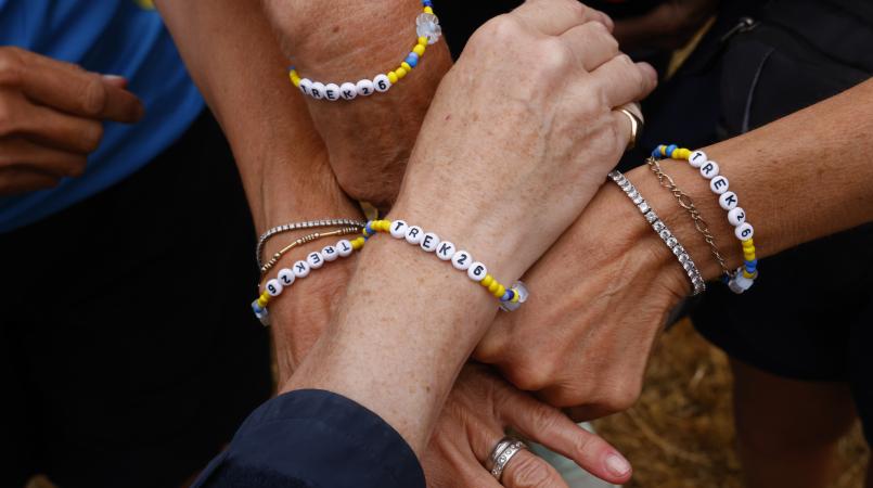 People with friendship bracelets saying Trek26 on them.