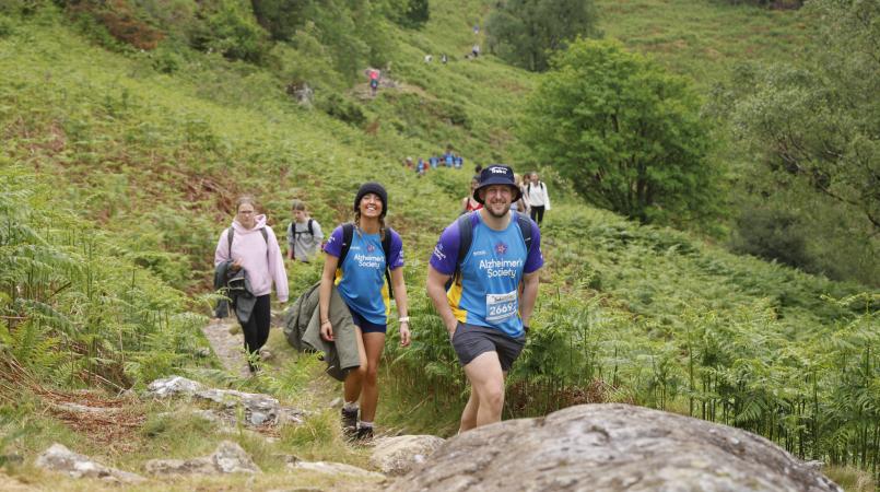 A group of people walking up a rocky hillside.