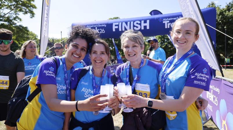 Group of ladies smiling with medals and prosecco.