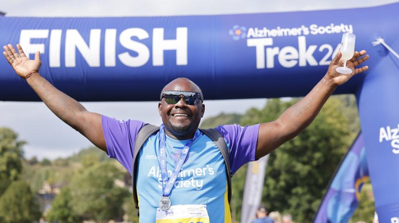 Man with arms raised celebrating crossing a finish line.