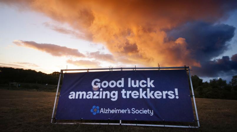 Good luck trekkers sign in front of a red cloudy sky.
