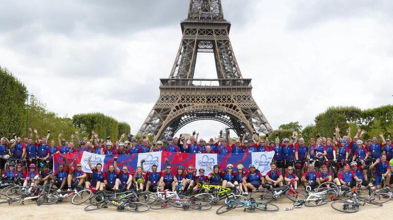 A group of cyclists in front of the Eiffel Tower