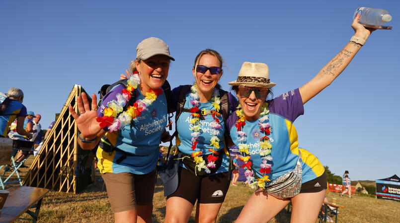 A group of people in flower necklaces smiling at the camera.