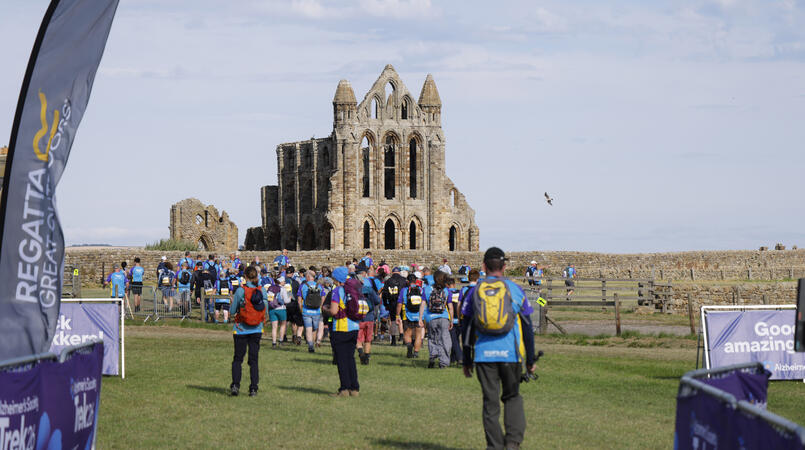 A large group walking away from the camera at a trek26 start line.