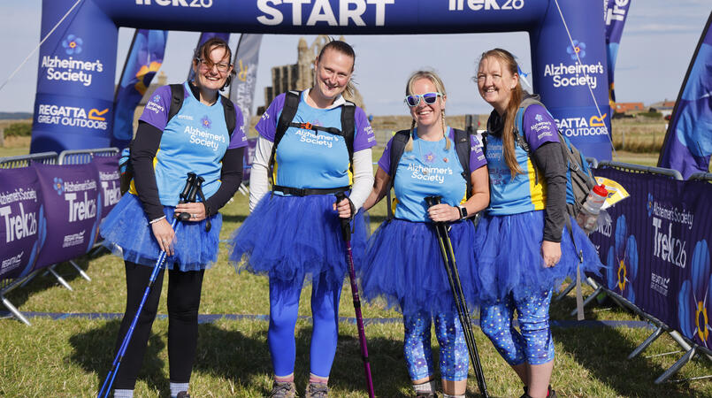 A group of 4 wearing tutus and smiling at the camera.