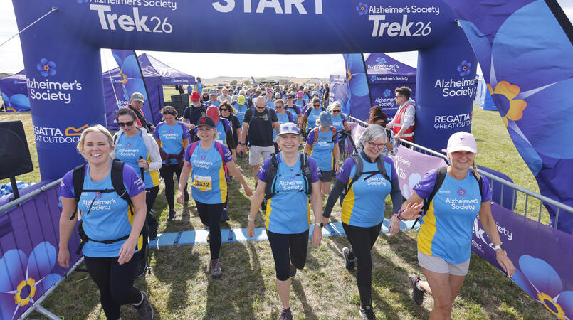 A group of people setting off at a trek26 start line.