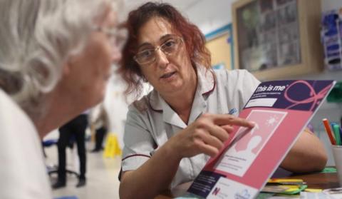 Nurse shows a hospital patient 'This is Me' publication