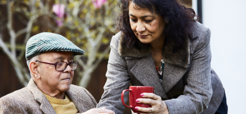 Image of a person with dementia and his carer enjoying tea