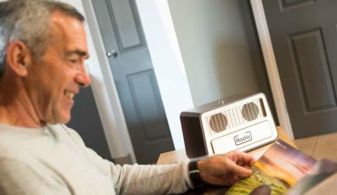 Man reading a magazine next to his one button radio