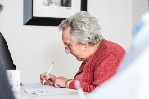 Person living with dementia writing