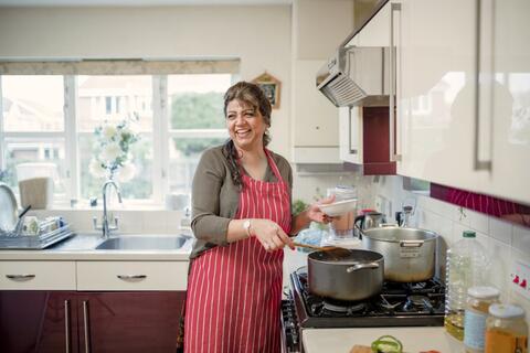Woman in red apron cooking