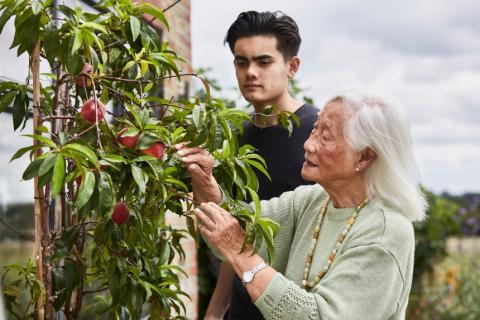 A woman with dementia tending to her plants with her grandson