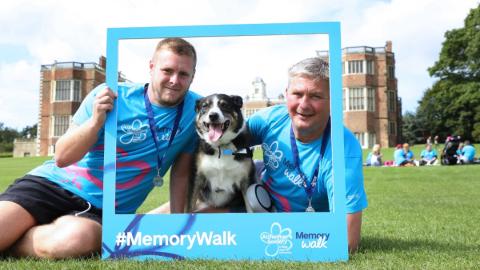 Two men posing with a dog at Leeds Memory Walk