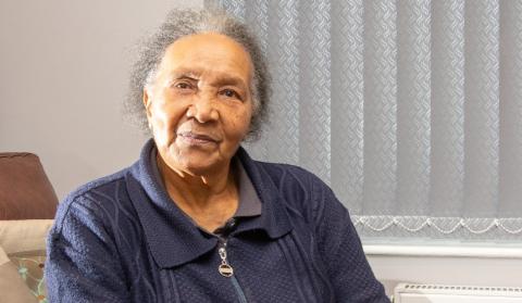Mavis Blake, an older woman of colour, is smiling towards the viewer