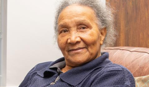 Mavis Blake, an older woman of colour, is smiling towards the viewer