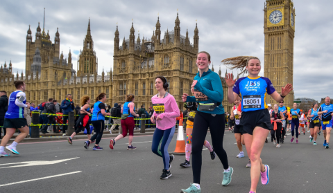 Runner smiling and waving in front of the Big Ben