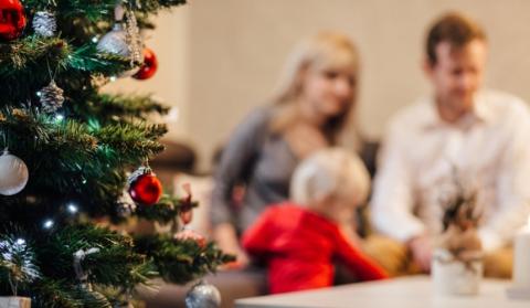A family sitting near a Christmas tree