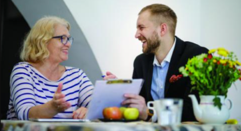 A solicitor sit at a table with a smiling client