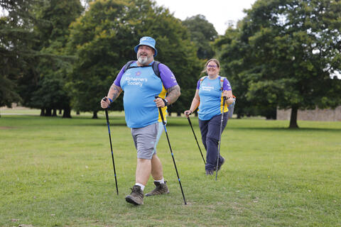 Two people trekking in a field.