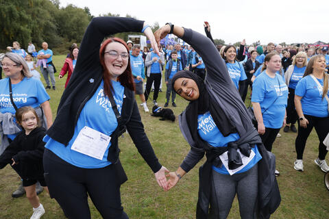 Two walkers create a 'heart' shape with their arms