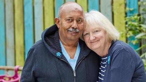 A man and woman hugging in a garden
