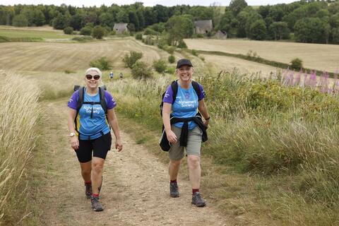 Two women walking on a country lane.