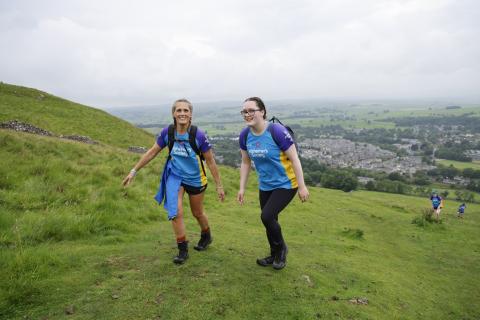 Two women walking on a hillside.