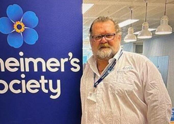 Paul Harvey in the office next to Alzheimer's Society signage