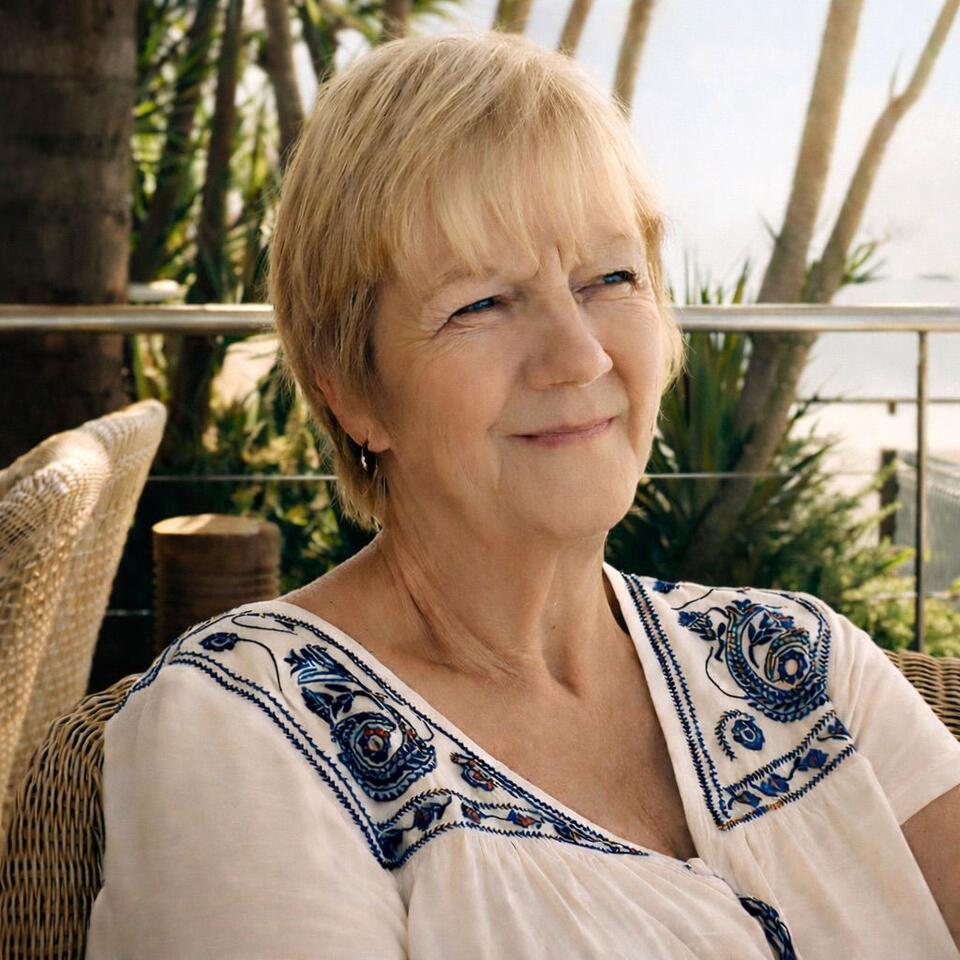 A woman with short blonde hair and white patterned top